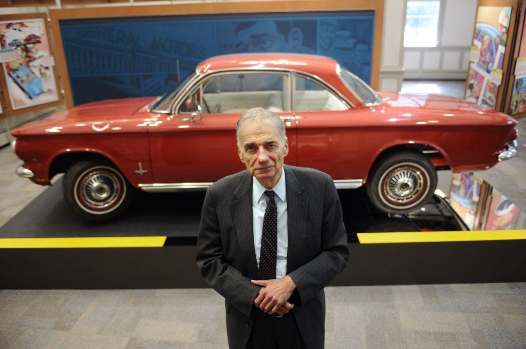 Ralph Nader posing in front of a Corvair car