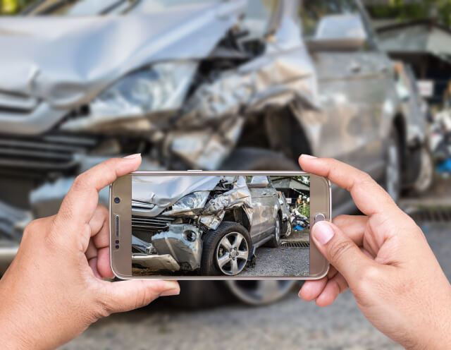 A car accident attorney in Georgia takes a photo of a car crash for evidence.
