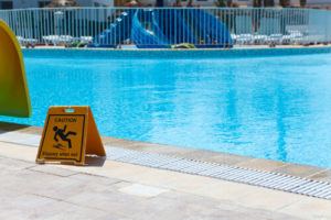 warning sign for a slippery floor by a swimming pool in Georgia