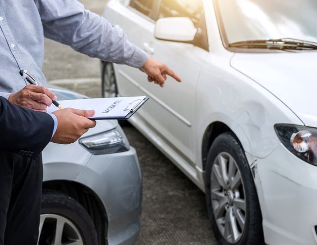 An insurance adjuster looks at a car accident in Georgia.