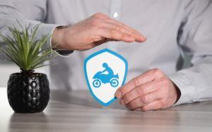 Man protecting the motorcycle with his hand showing motorcycle insurance concept.