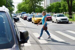 Woman walking on pedestrian crossing.