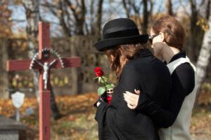 Wife grieving in the cemetery over her loss husband.