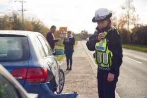 Woman police officer checking on car accident.