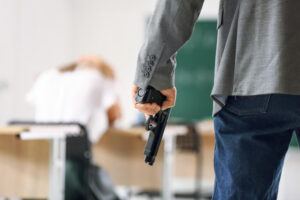 Male terrorist holding gun inside the classroom.
