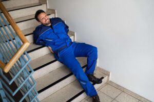 Employee feeling pain after slipping on the staircase.