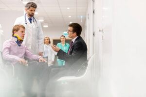 Injured client with his doctor on the side, talking to his lawyer for claim.