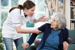 Caregiver in the nursing home abusing the terrified senior.